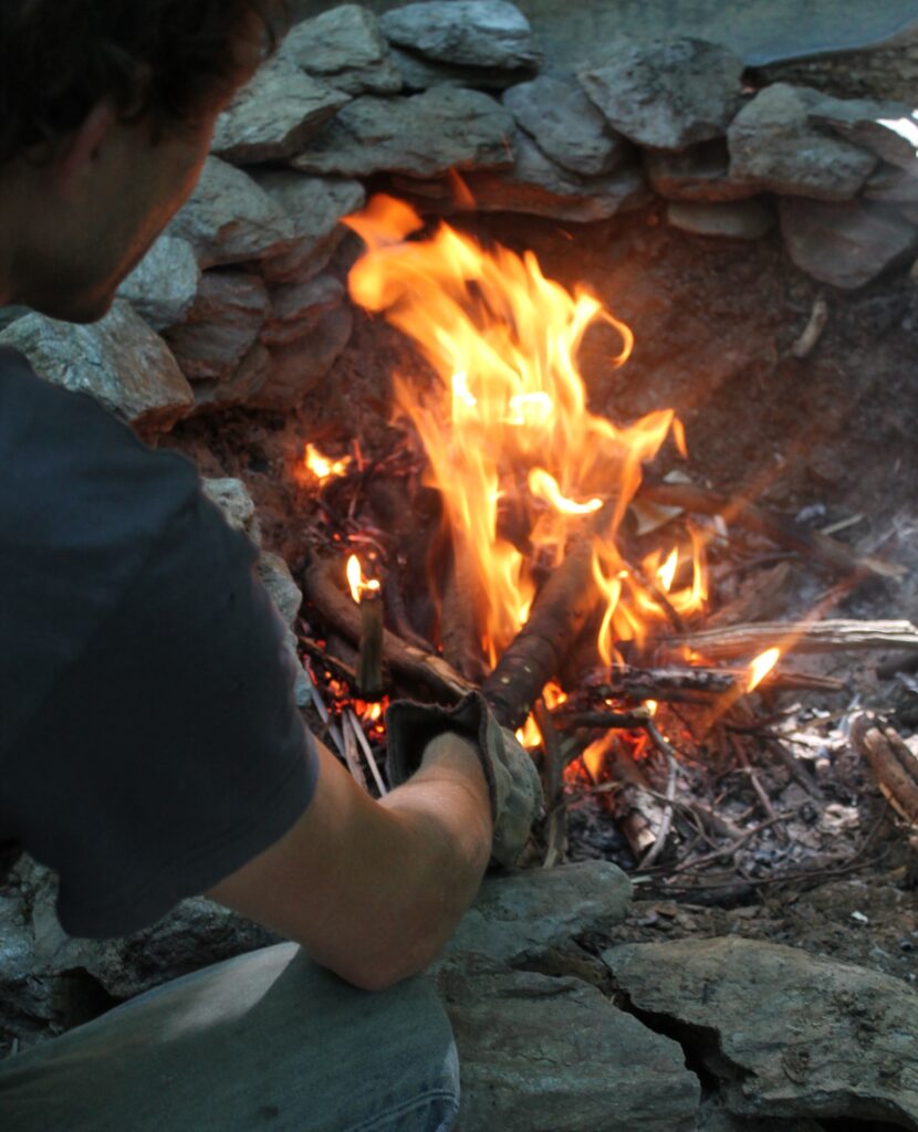 chauffage du bois sur le feu une branche est chauffée sur un feu de bois, directement sur les flammes